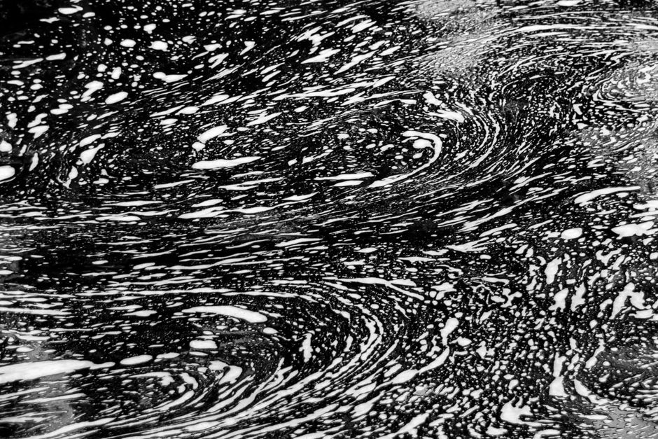 Dynamic abstract black and white texture with swirling patterns and motion effect.